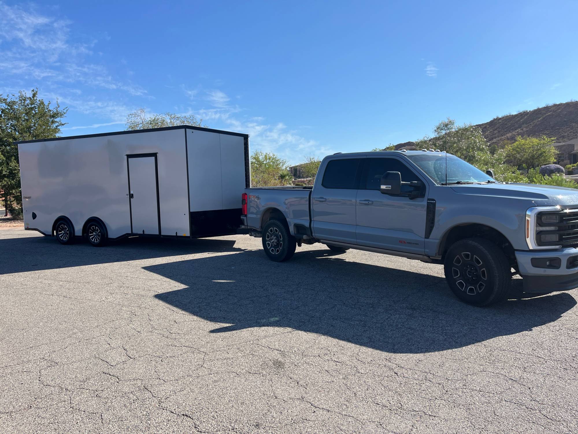 Apple Pie Transport rig — a Super Duty diesel pickup hitched to a fully enclosed white trailer under a desert sky